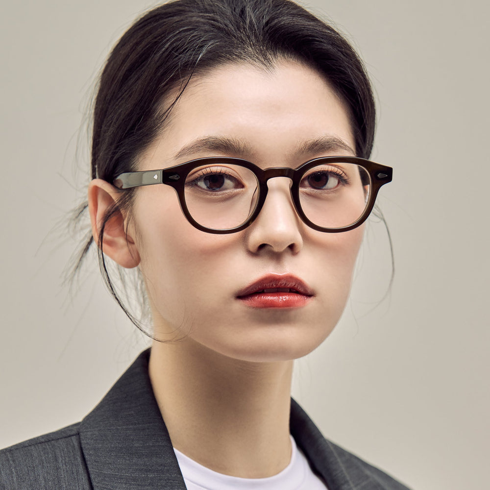 Woman in round CARIN glasses and a grey blazer