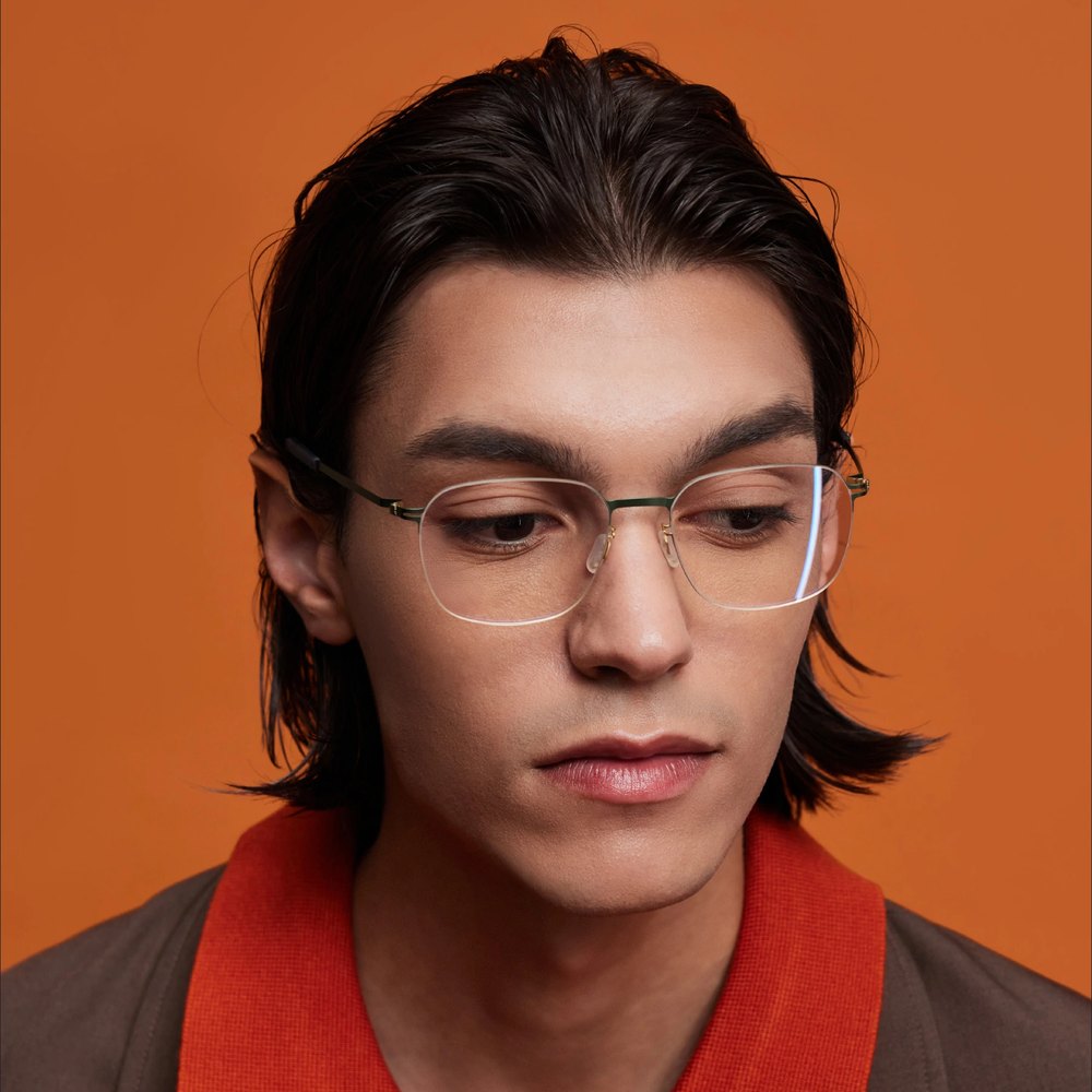 Man in VYCOZ glasses against an orange wall