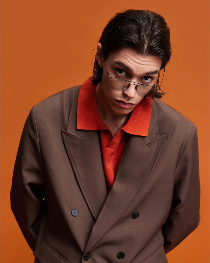 Man in VYCOZ glasses, a brown blazer and a red shirt