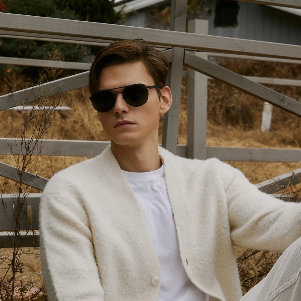 Man in VYCOZ sunglasses and a cream cardigan