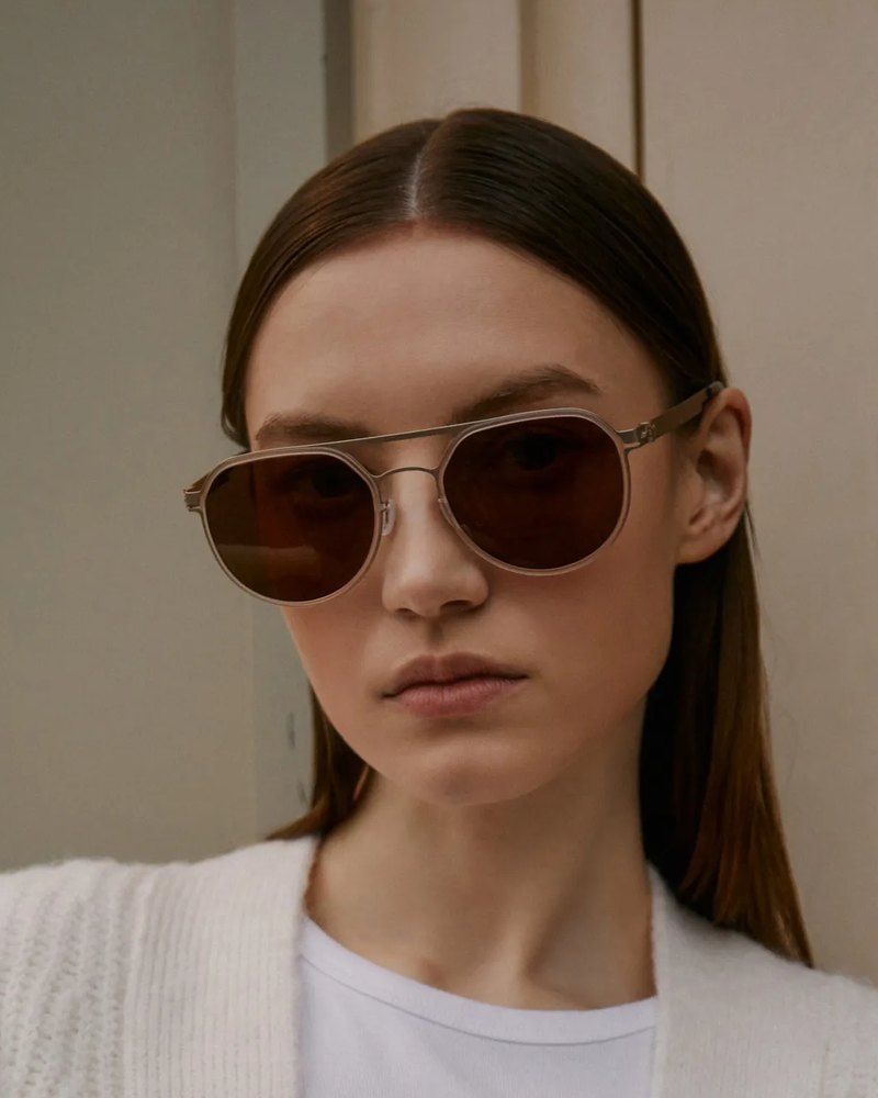 Woman in VYCOZ sunglasses and a cream sweater