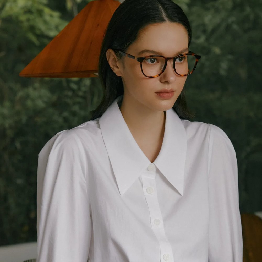 Woman in VYCOZ acetate glasses and a white blouse